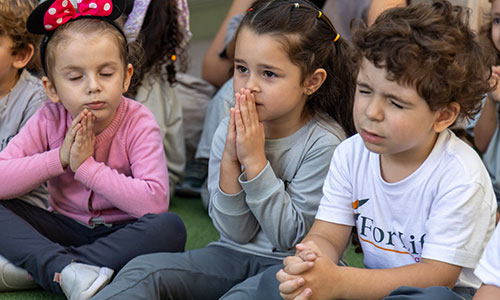 Crianças rezando em escola cristã bilíngue